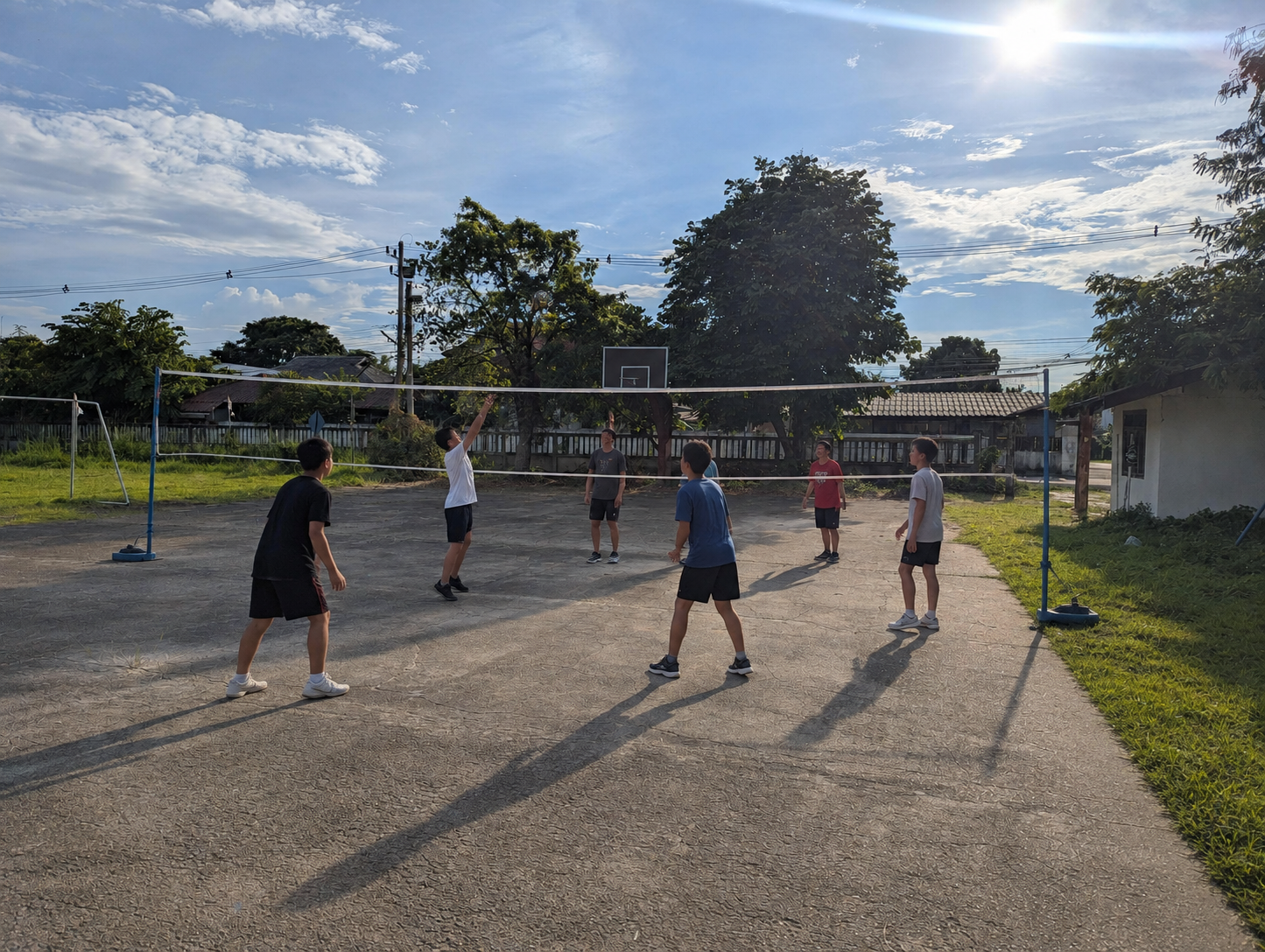 Learners playing volleyball on the neighboring multi-use outdoor court
